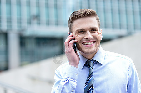 在电话上说话的笑脸商务人士男性微笑商业经理生意人秘书管理人员男人工作街道图片