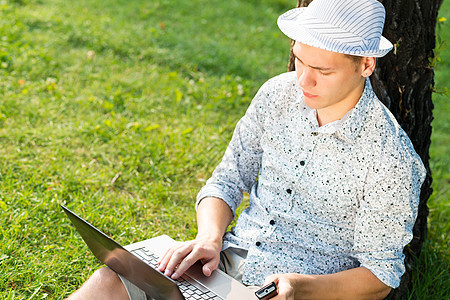 在公园用笔记本电脑工作的年轻人成功男性套装草地互联网蓝色商务衬衫男人男生图片
