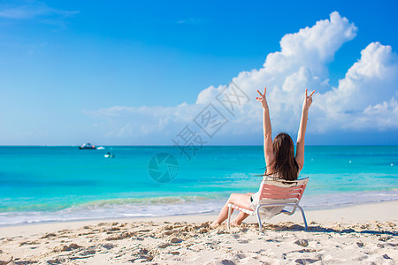 在暑假的沙滩椅子上 年轻快乐的女人图片