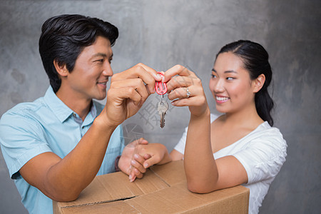 幸福的一对夫妇拿着房子钥匙 靠着搬家箱女性公寓住所搬迁快乐房地产男人女士闲暇盒子图片