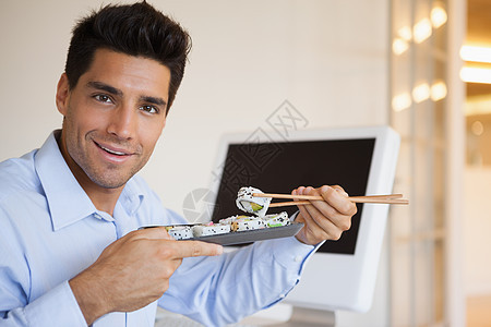 在办公桌吃寿司的零工生意人人士工作午休电脑时间微笑办公室健康饮食职业职场图片