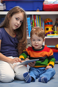 用数字平板电脑 和她的弟弟玩得开心的女孩乐趣教育幸福快乐技术闲暇触摸屏男生享受孩子们图片
