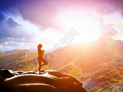 女人站在树瑜伽姿势 日落时在山上冥想图片