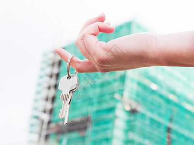 一个房地产经纪人 手里拿着新公寓的钥匙 他把钥匙放在她手上建筑手指抵押建筑学家庭财产销售保险投资贷款图片