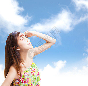 年轻女子举手用蓝天遮照阳光图片