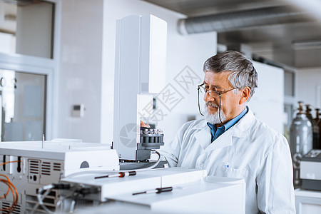 在实验室进行科学研究的高级男性研究员学习化学家显微镜化学品测试气体职业微笑液体色谱仪图片