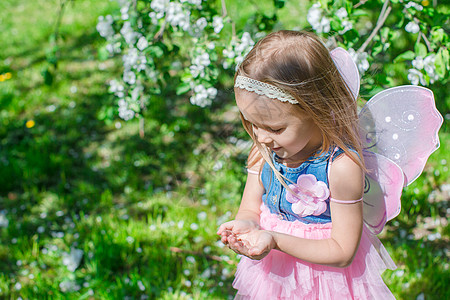 在开花的苹果园里 一只小姑娘手里拿着只大虫图片