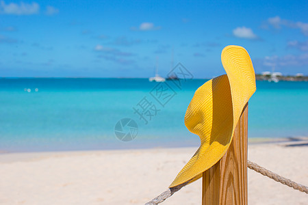 Caribbean岛海滩围栏上的黄帽子酷暑支撑海洋广告晴天天堂海景逃离假期风景图片