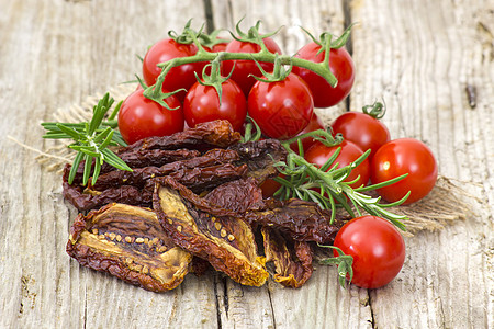 木制背景的鲜红番茄和干西红柿草本植物味道迷迭香美食脱水蔬菜小吃红色食物香料图片