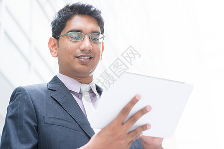 使用计算机平板板的印度商务人士图片