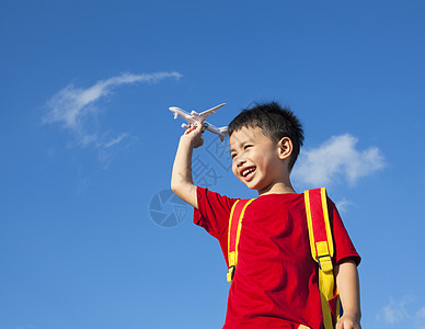 飞机梦小男孩拿着一个带背包的飞机玩具幼儿园太阳自由孩子手指喜悦天空幸福乐趣季节背景