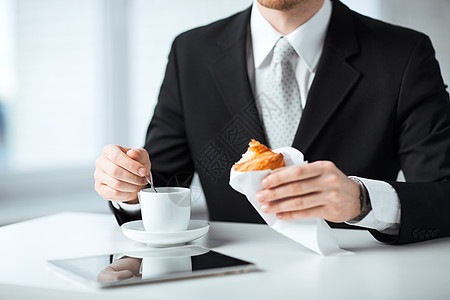 男人用平板电脑和咖啡杯商业互联网餐饮小吃羊角食物咖啡职场饮料研讨会图片