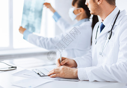 检查X光的医生和护士讨论医疗保险食谱写作床单女士长袍探索医院医务人员图片