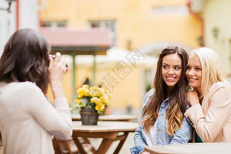 在城市咖啡馆拍照的漂亮女孩假期朋友们享受街道相机乐趣团体游客楷模摄影师图片