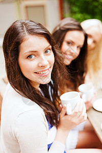 在咖啡馆喝咖啡的漂亮女孩假期杯子饮料朋友们桌子团体旅游街道女性城市图片