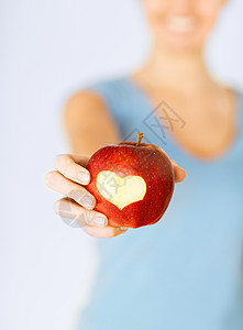 手握红苹果 心脏形状的妇女奉献卫生损失重量维生素有氧运动保健生态生物产品图片