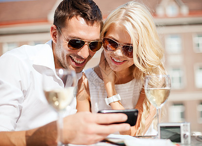 一对夫妇在咖啡馆看智能手机细胞互联网色调男人假期游客男朋友视频夫妻咖啡店图片