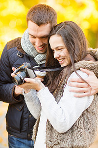 秋天公园有相片摄影机的情侣女士女孩游客照片蜜月旅游友谊公园季节假期图片
