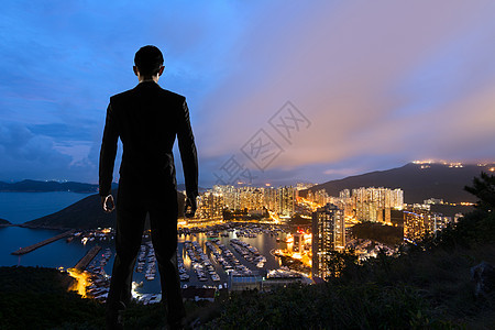 站在山丘上的亚洲商务人士经理管理人员建筑学摩天大楼套装人士男人景观商务手表图片