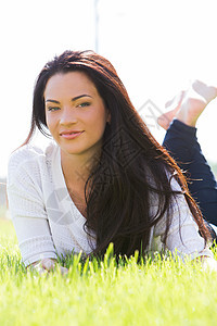 草地上美丽的女人皮肤公园衣服女性眼睛阳光微笑裙子女士黑发图片