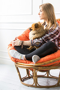 带着狗的漂亮女人椅子女性橙子裙子宠物美丽衬衫哺乳动物女孩公寓图片
