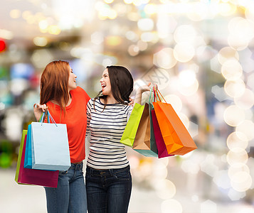 2个带着购物袋笑着的少女女孩假期青少年幸福购物中心购物零售顾客购物者季节快乐图片