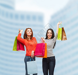 2个带着购物袋笑着的少女女孩零售财富城市奢华购物幸福商业女孩们购物狂摩天大楼图片
