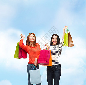 2个带着购物袋笑着的少女女孩财富蓝色女孩们购物者零售购物狂假期购物快乐青少年图片