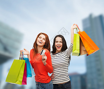 拥有购物袋和信用卡的少女女孩人数消费者塑料销售购物狂提倡者购物者假期快乐礼物商业图片