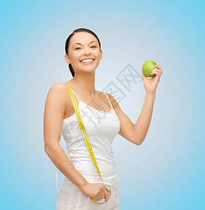 配有苹果和测量胶带的运动妇女数字培训师腰部女性蓝色饮食控制女孩微笑教练图片