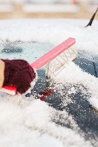 妇女从汽车后窗中打扫雪窗户工具车辆女性降雪司机刷子天气雪花扫帚图片