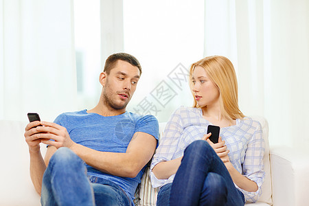 家里有智能手机的集中夫妇家庭长椅夫妻恋人男生男人女士社会技术思维监督图片