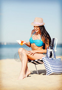 女孩在沙滩椅上晒日光浴系数棕褐色防晒身体休息室躺椅防晒霜热带保湿旅游图片
