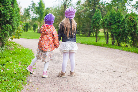 公园里可爱的小女孩乐趣场地草地幸福卷曲植物孩子友谊朋友情感图片