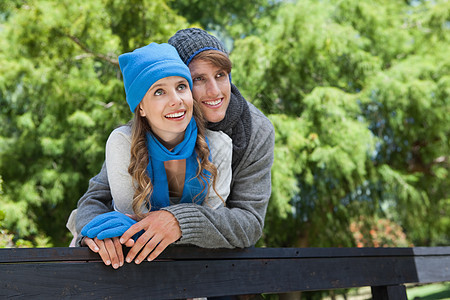 站在公园的一对可爱情侣 围着栅栏女朋友女性绿地手套夫妻棕色金发阳光感情潮人图片