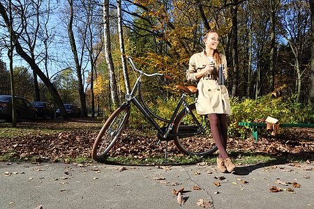 城市自行车娱乐远足橙子喜悦幸福女士帽子公园黑发树叶背景图片