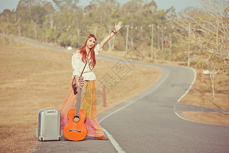 嬉皮女孩搭便车女孩旅行自由拇指街道运输音乐家青年游客国家图片