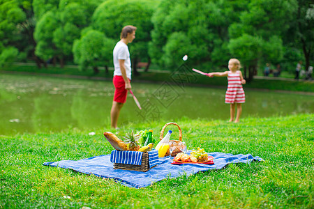 家庭在公园野餐快乐童年孩子羽毛球假期女士享受父亲闲暇娱乐篮子图片