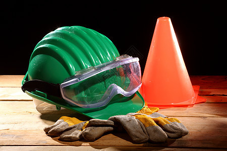聚光灯中的安全工业绿色工人手套警告生活警卫头盔工具衣服图片