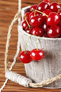 水果樱桃海报林木桶里有水滴的新樱桃风化木头甜点团体棕褐色水果红色饮食食物生活背景