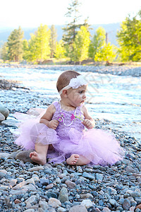 婴儿女婴阳光花朵短裙紫丁香孩子童年黑发鹅卵石女性海滩图片