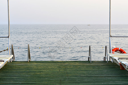带金属扶手的木制码头栏杆支撑风景天桥热带假期建筑学港口蓝色海滩图片