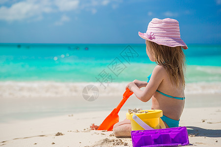 可爱的小女孩在海滩度假时玩玩具游戏海洋游泳衣闲暇海滨热带假期快乐青年女儿童年图片