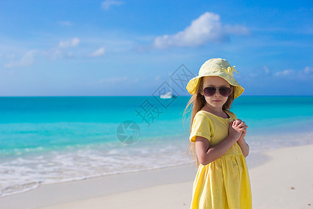 暑假期间在白沙滩上可爱的小女孩海洋帽子旅游裙子海岸海岸线幸福海滩太阳喜悦图片
