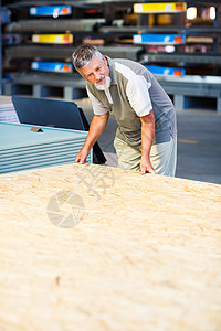 男子在一家DIY商店中选择和购买建筑木柴房子男性木头工作男人建设者店铺木材安全帽住宅图片
