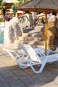 游泳池的阳光水池游客闲暇季节棕榈海滩天堂天空旅行游泳图片