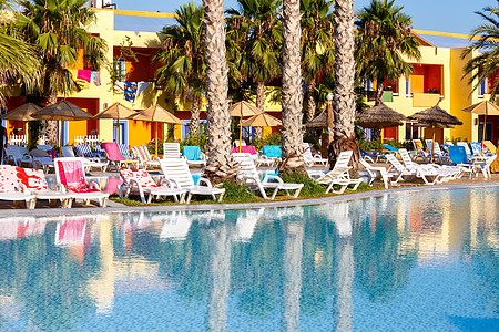 游泳池的阳光天空休息季节财富日出闲暇假期棕榈奢华热带图片