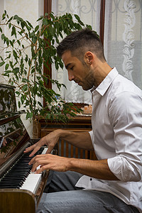 年轻 英俊的男子艺术家弹钢琴图片