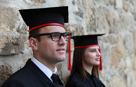 毕业日的年轻夫妇人数学校快乐学生喜悦证书成人眼镜帽子成就大学图片
