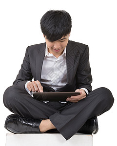 亚洲商务人士使用垫板和坐在地上身体人士屏幕药片技术软垫工作室触摸屏男人展示图片